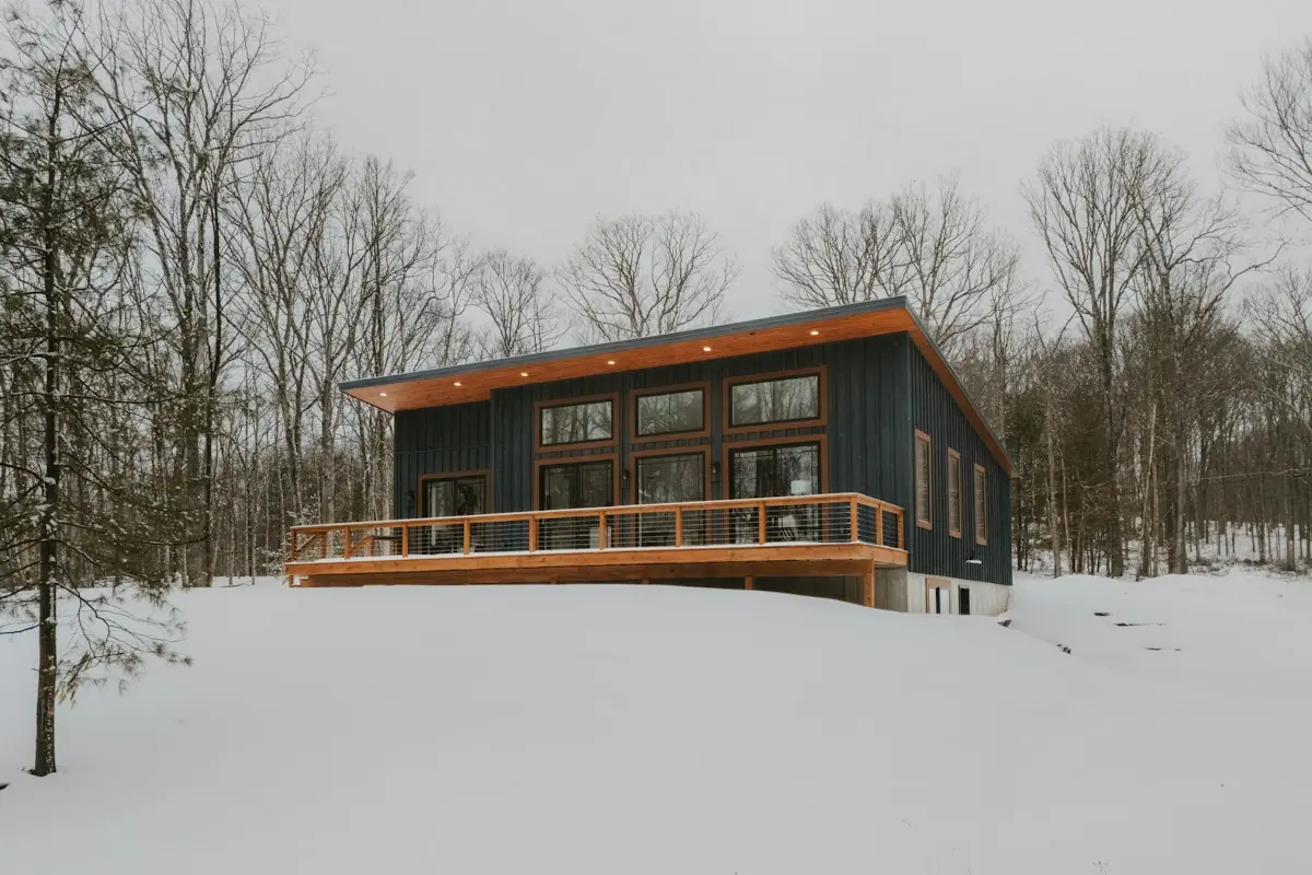 雪の中に建つ木の家